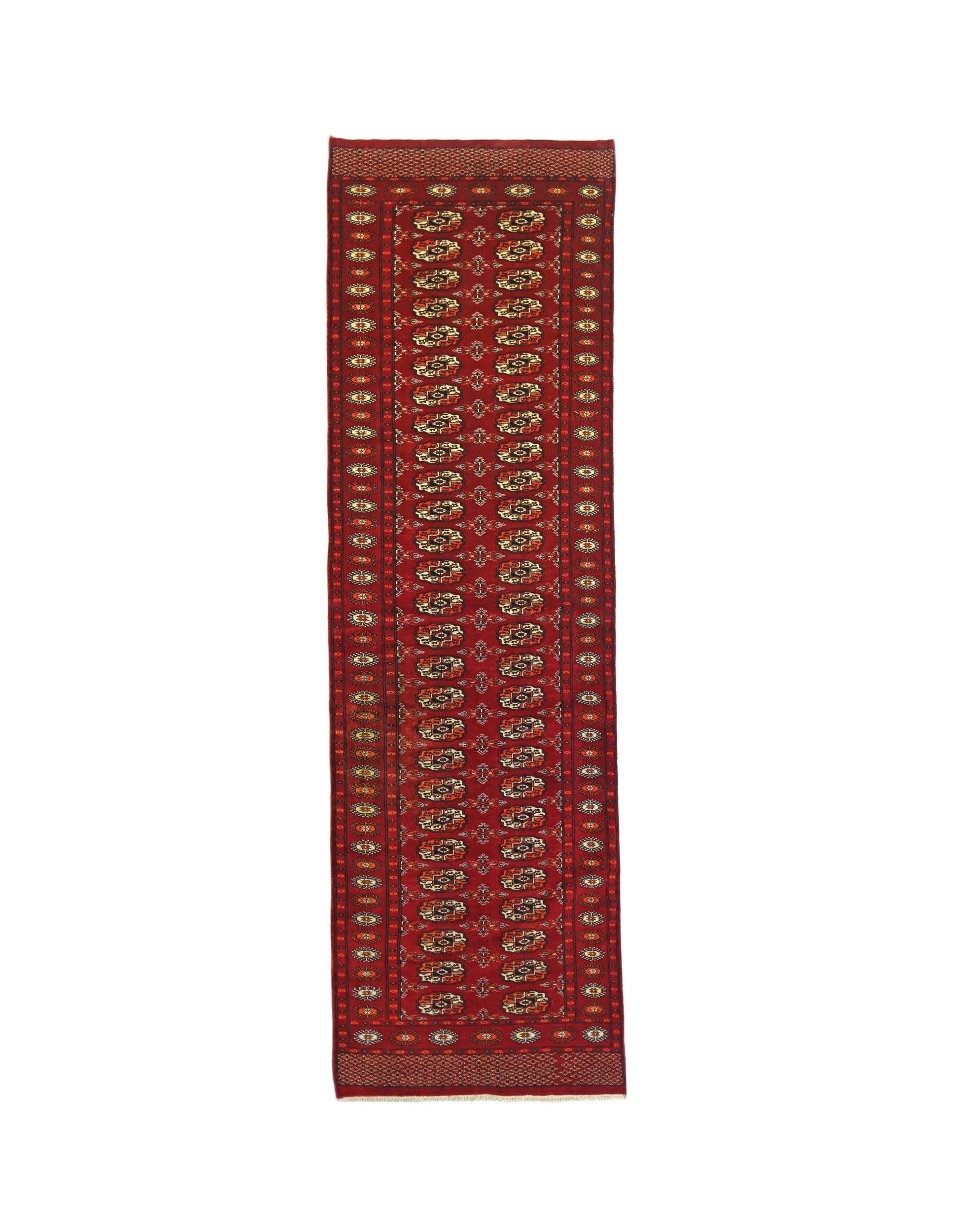 A vintage Pakistani Princess Bokhara runner featuring a deep red field with repeating geometric motifs.