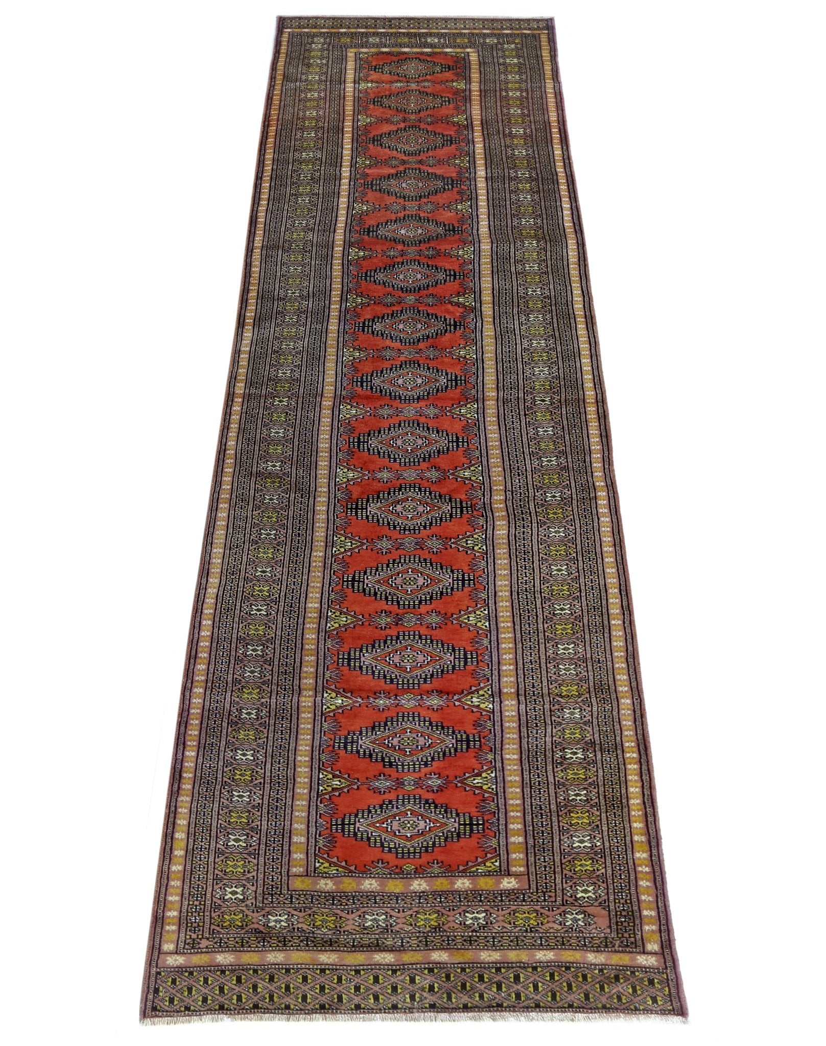 A vintage Pakistani Princess Bokhara runner featuring repeating diamond motifs on a red background.