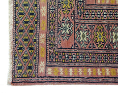 A vintage Pakistani Princess Bokhara runner featuring geometric patterns in pink, yellow, and black.