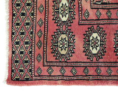 A vintage Pakistani Princess Bokhara runner featuring a red field with repeating geometric motifs.