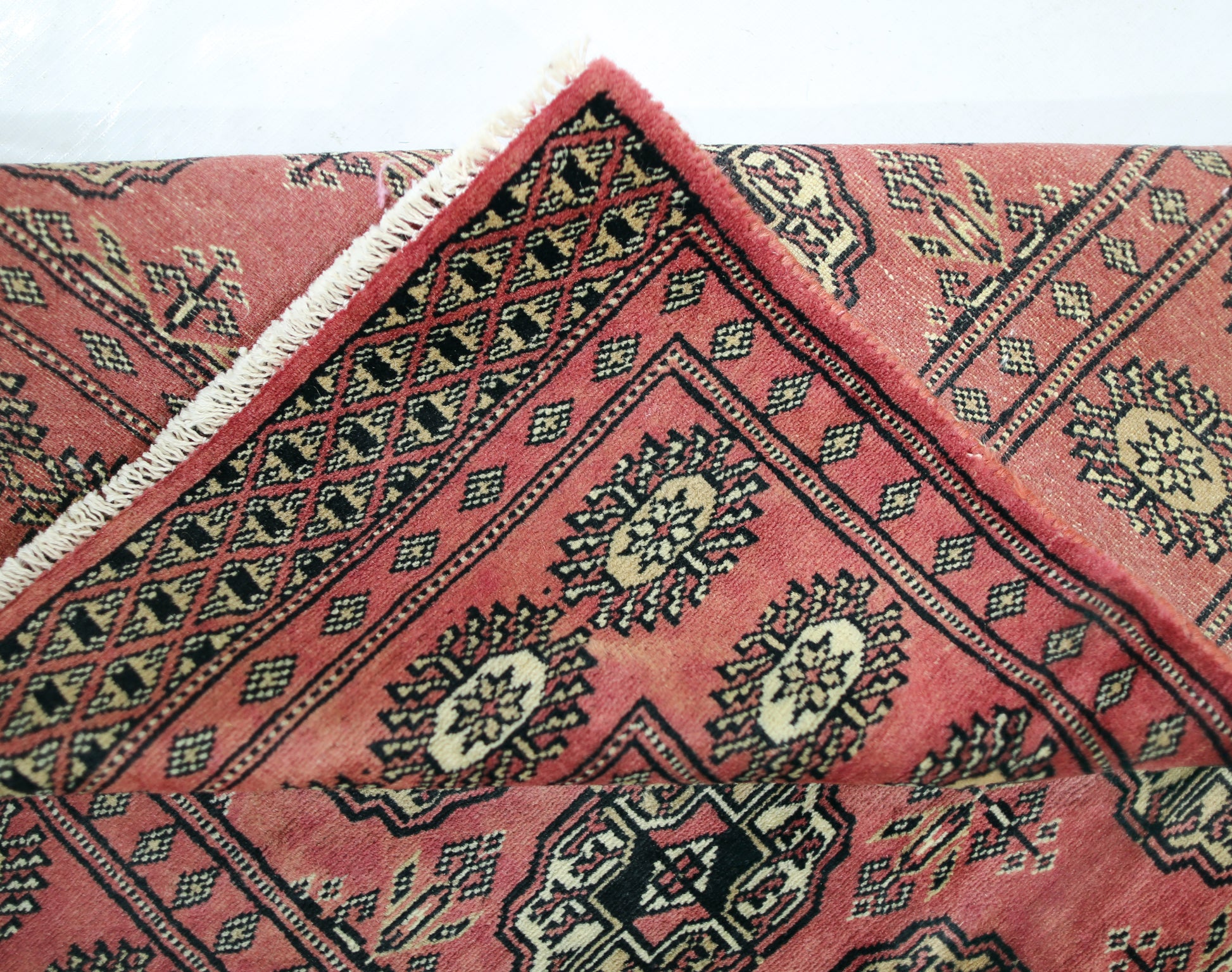 A vintage Pakistani Princess Bokhara runner featuring a red field with black and cream geometric motifs.