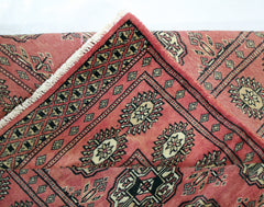 A vintage Pakistani Princess Bokhara runner featuring a red field with black and cream geometric motifs.