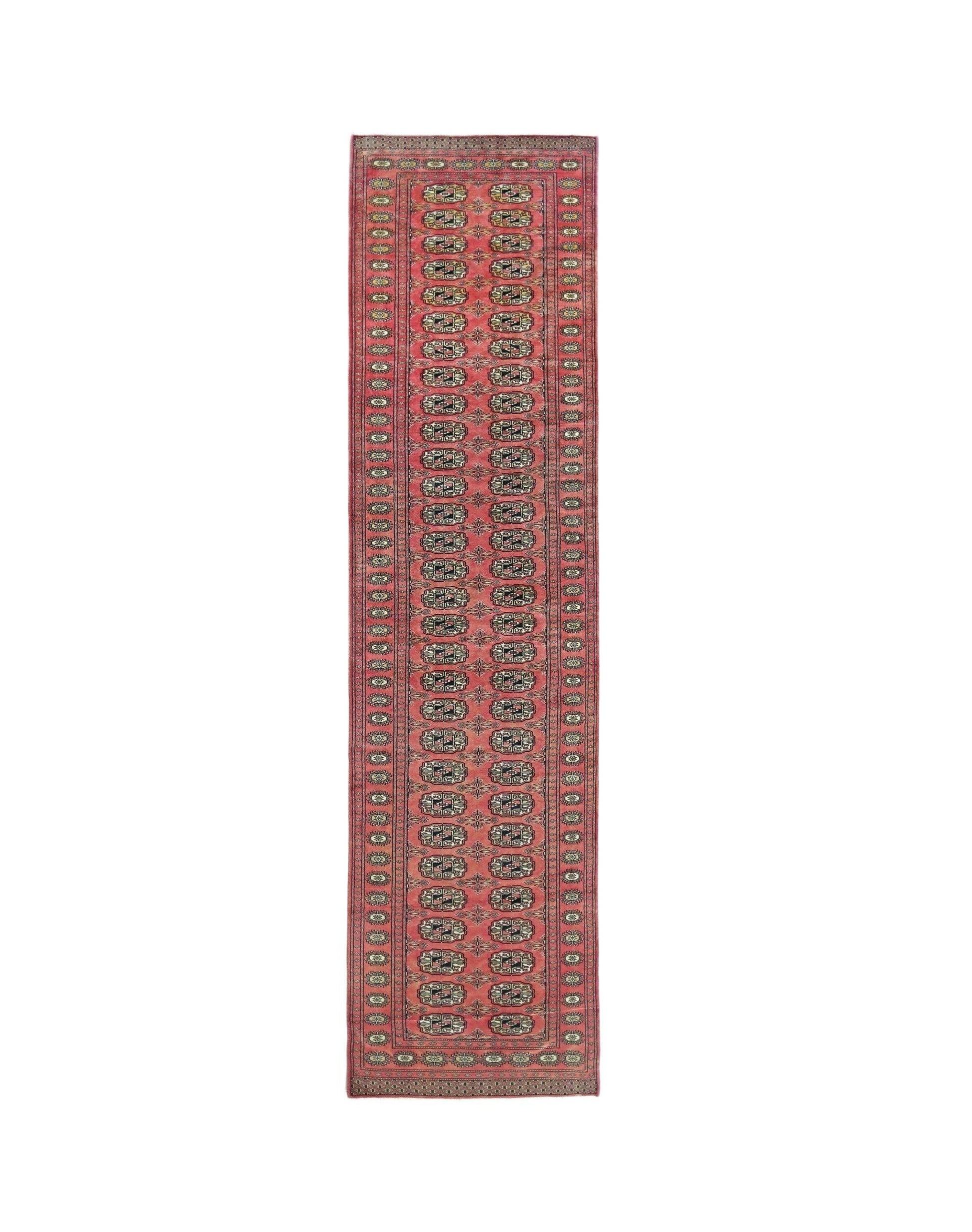A vintage Pakistani runner rug featuring a repeating geometric pattern in red and cream tones.