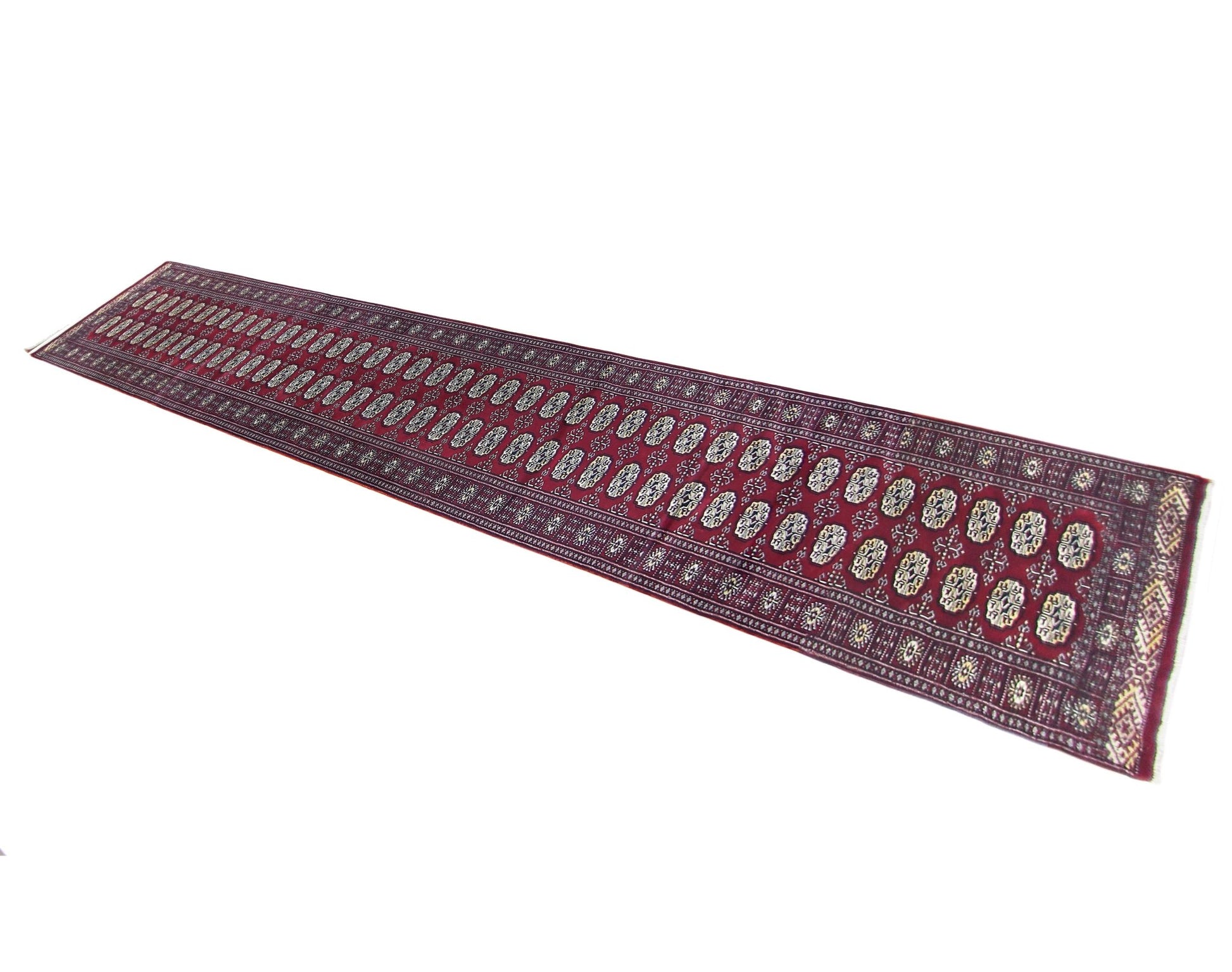A long, vintage Pakistani Princess Bokhara runner rug featuring a repeating geometric pattern.