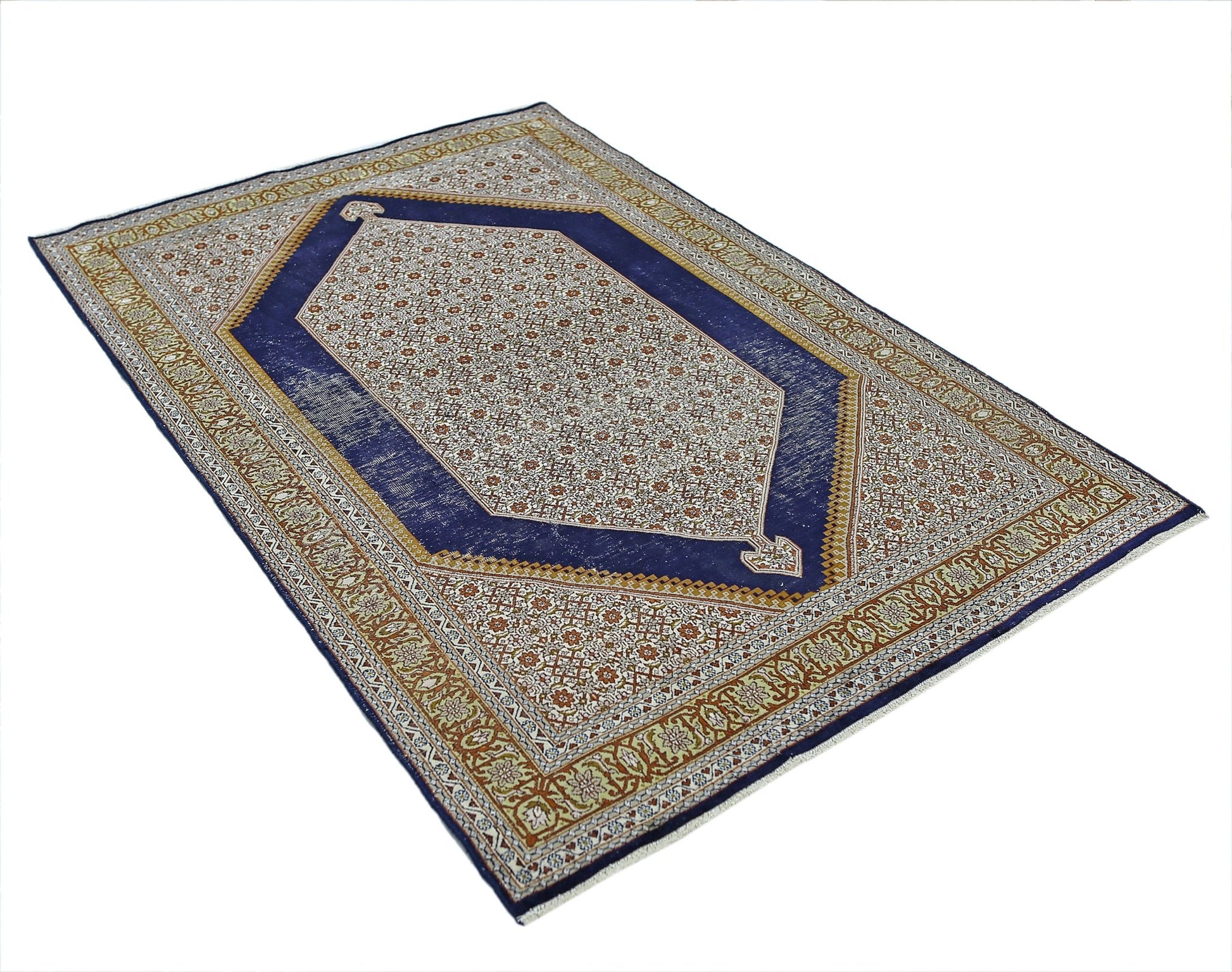 A vintage handmade Kashmiri silk rug featuring a central hexagonal medallion on a blue field.