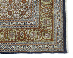 A vintage silk Kashmiri rug featuring intricate floral patterns in shades of green and rust.