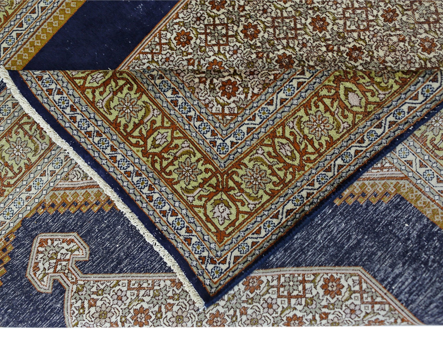 A vintage silk Kashmiri rug featuring intricate floral patterns in blue, orange, and cream tones.