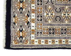 A vintage Pakistani Princess Bokhara rug featuring intricate geometric patterns in brown, cream, and black.