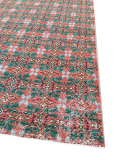 A vintage handmade Turkish wool rug featuring a repeating geometric pattern in red and green.