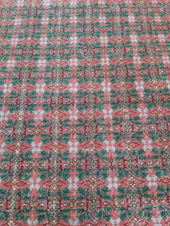 A vintage handmade Turkish wool rug featuring a repeating geometric pattern in red, green, and blue.