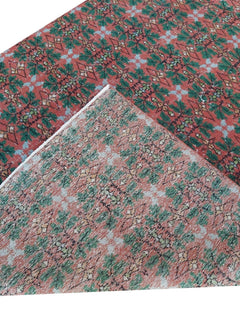 A vintage handmade Turkish wool rug featuring a repeating geometric pattern in red and green.