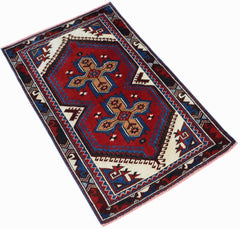 A handwoven vintage Turkish rug featuring a red central field with two tan cross-shaped motifs.