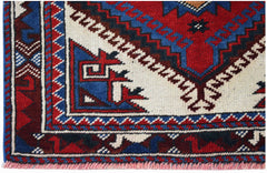 A handwoven vintage Turkish rug featuring geometric patterns in red, blue, and cream wool.