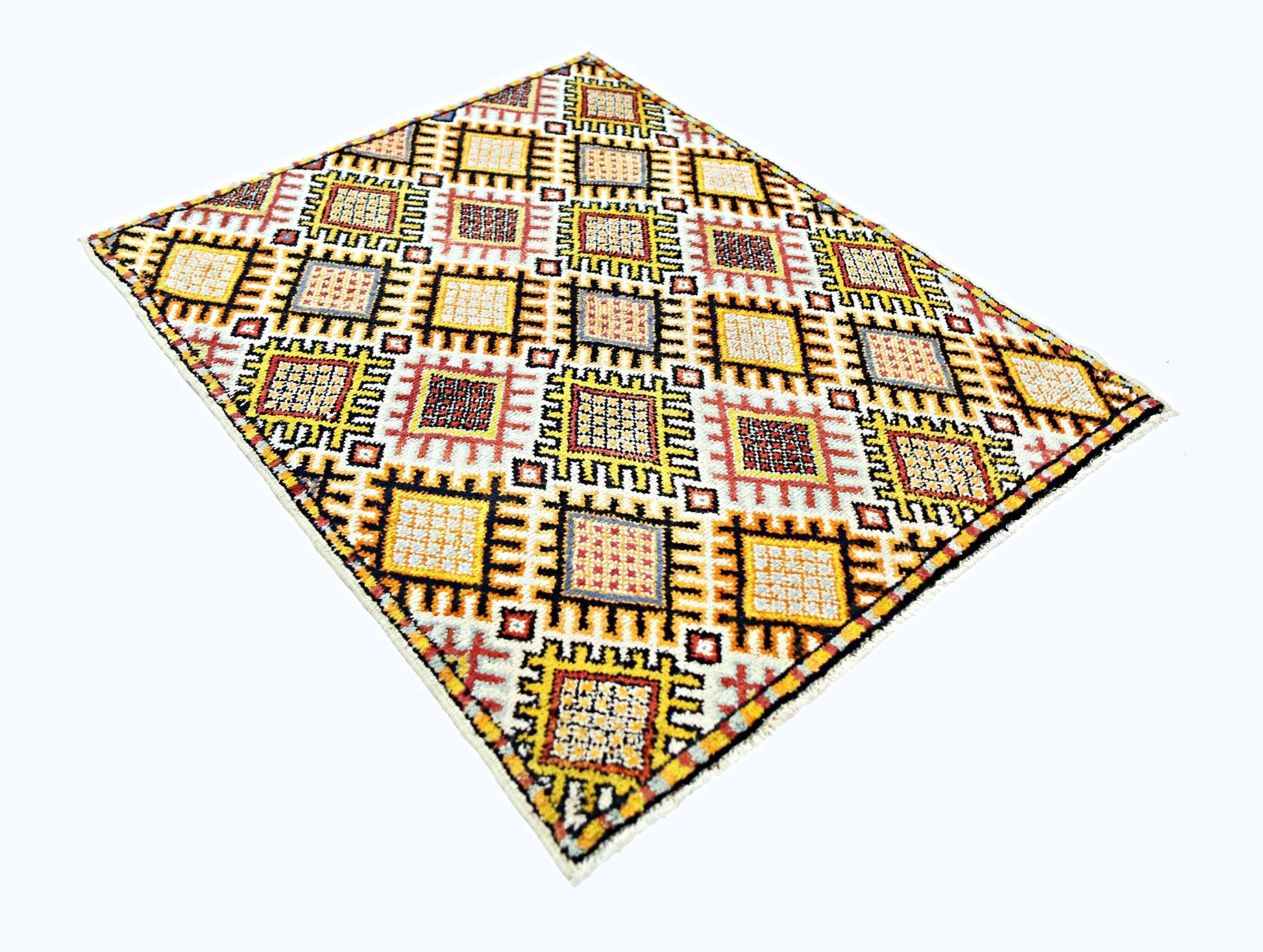A vintage handmade Turkish rug featuring a geometric grid pattern in yellow, red, and blue tones.