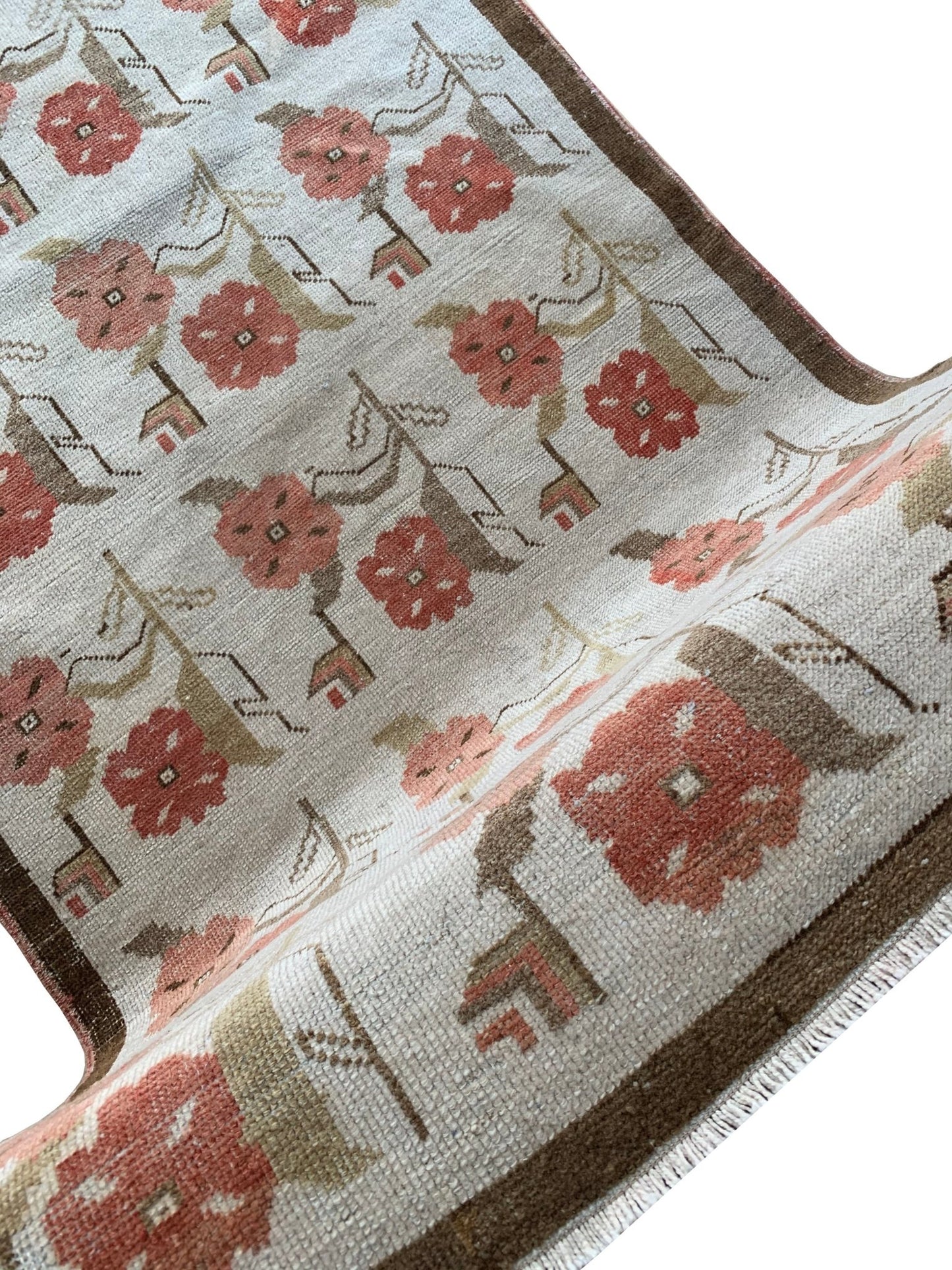 A vintage Turkish Oushak rug featuring a floral tulip pattern in muted red and brown tones.