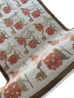 A vintage Turkish Oushak rug featuring a floral tulip pattern in muted red and brown tones.