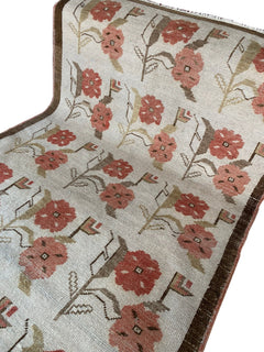 Vintage Turkish Oushak rug featuring a floral tulip pattern in muted pink and brown tones.