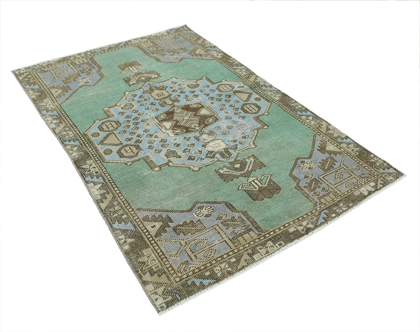 A vintage handmade Turkish rug featuring a central geometric medallion in teal, blue, and brown.