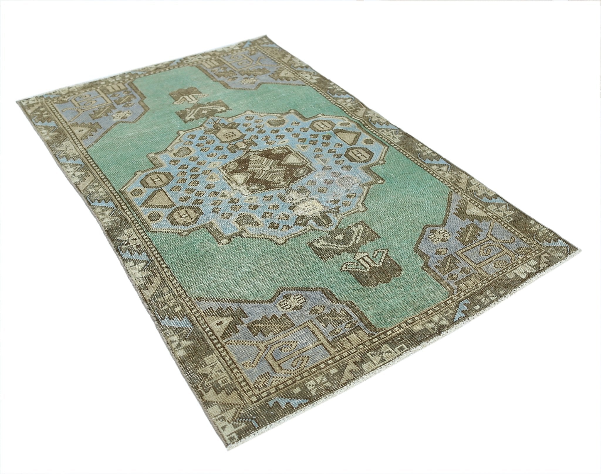 A vintage handmade Turkish rug featuring a central geometric medallion in teal, blue, and brown.