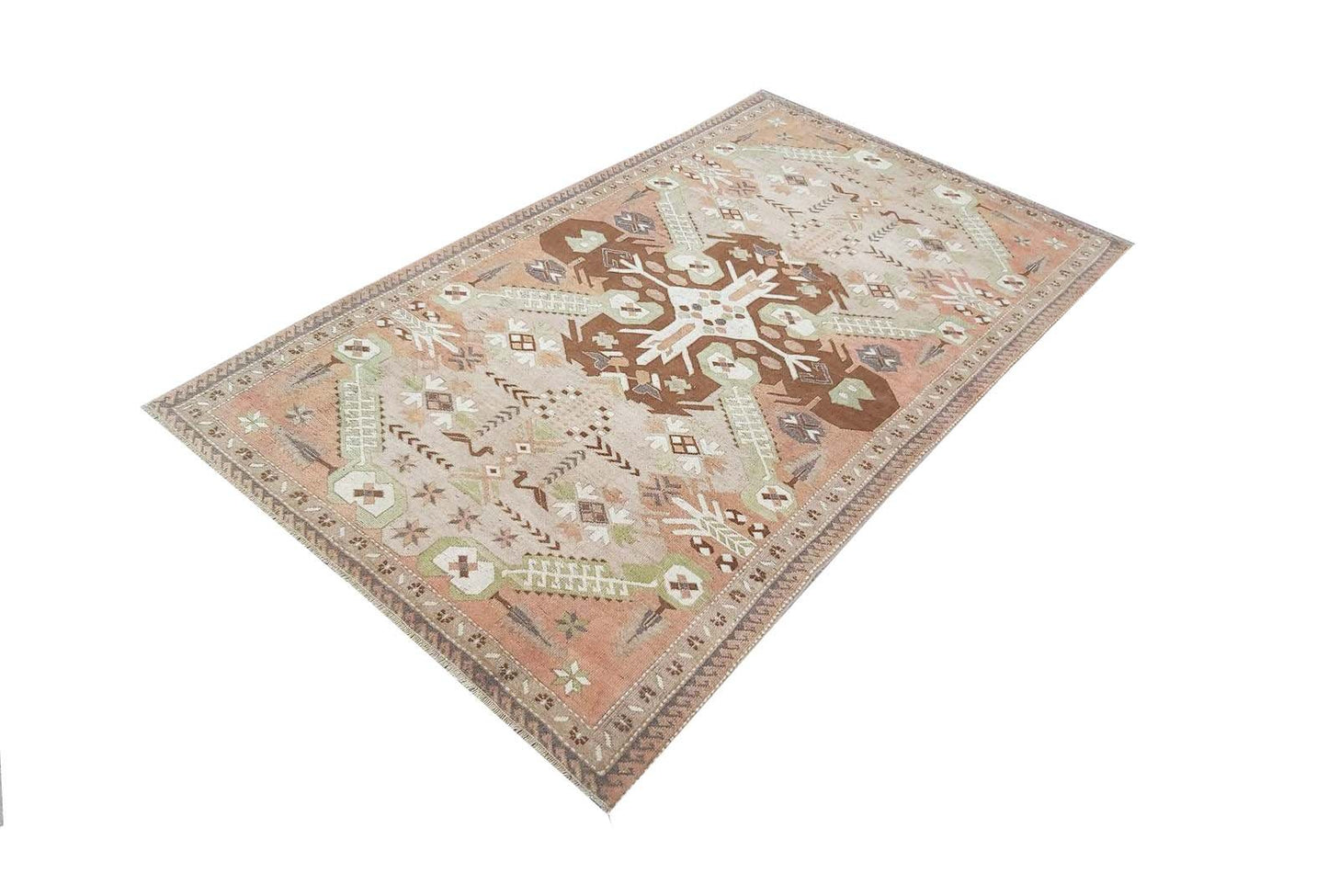 A vintage handmade Turkish rug featuring geometric patterns in shades of brown, green, and peach.