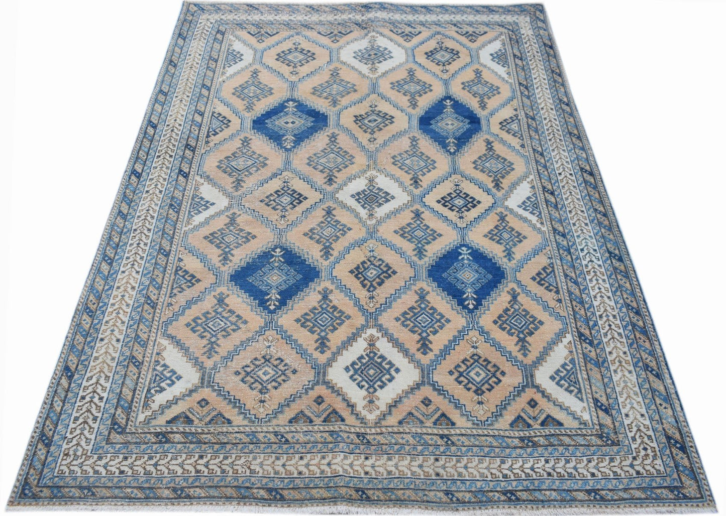 A vintage Persian rug featuring a geometric diamond pattern in shades of blue and beige.
