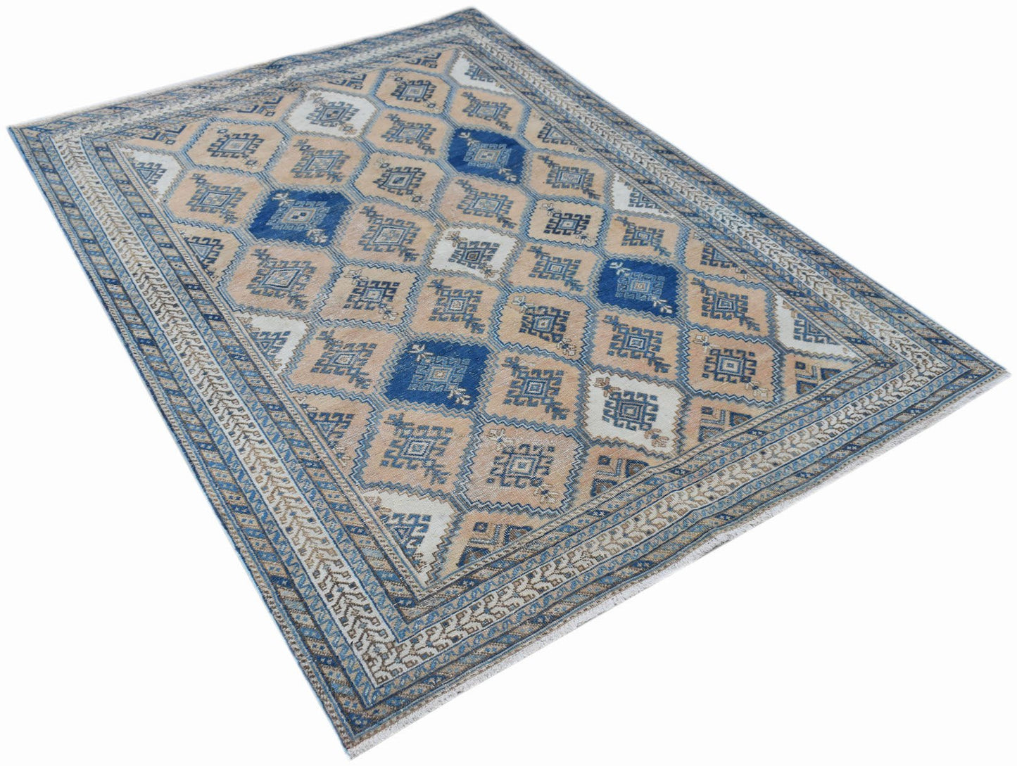 A vintage Persian rug featuring a traditional geometric diamond pattern in blue and beige tones.