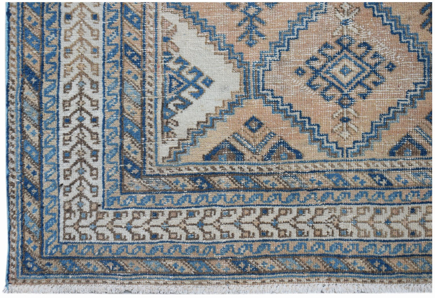 A vintage Persian rug featuring a traditional geometric pattern in shades of blue, tan, and cream.