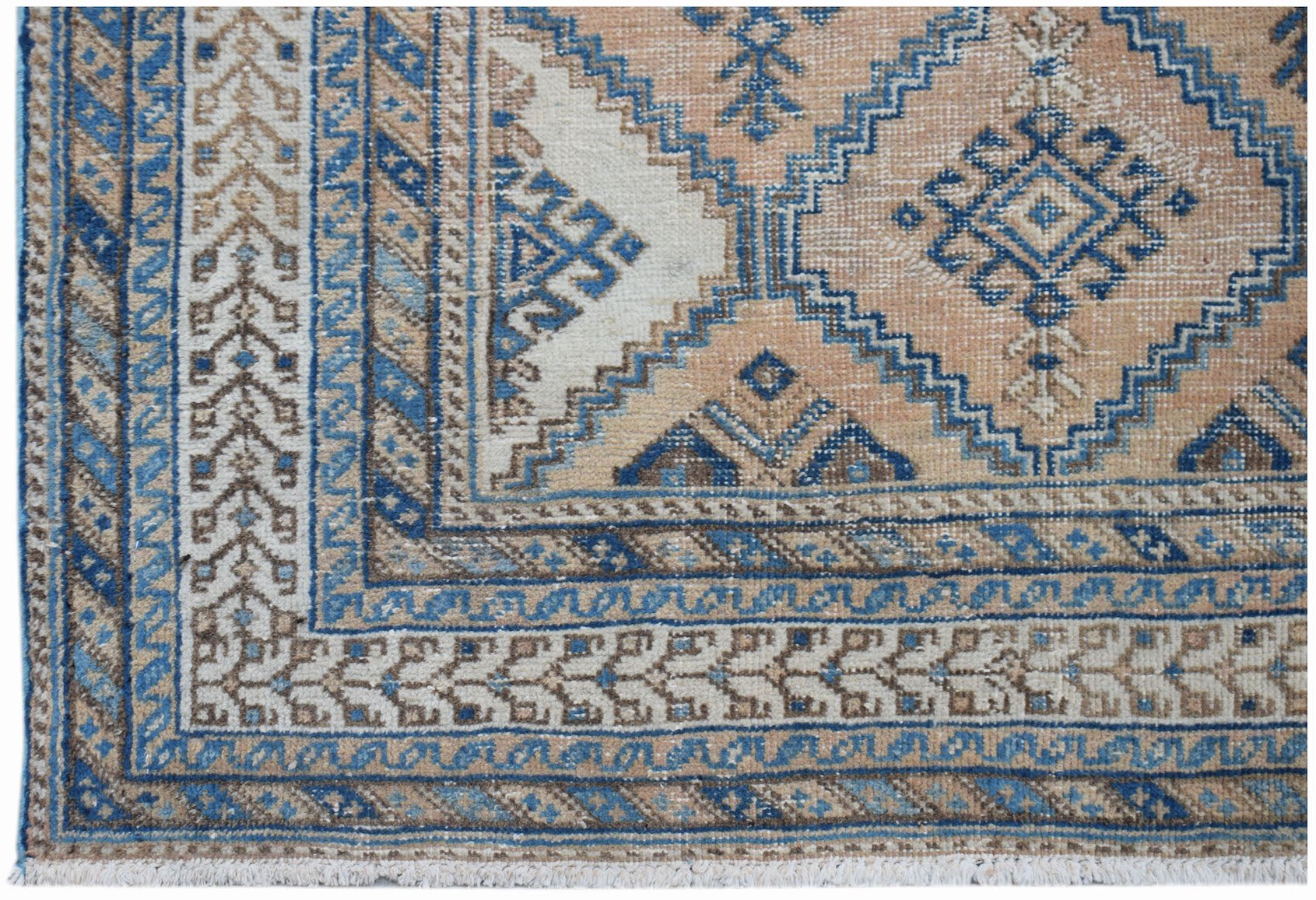 A vintage Persian rug featuring a traditional geometric pattern in shades of blue, tan, and cream.