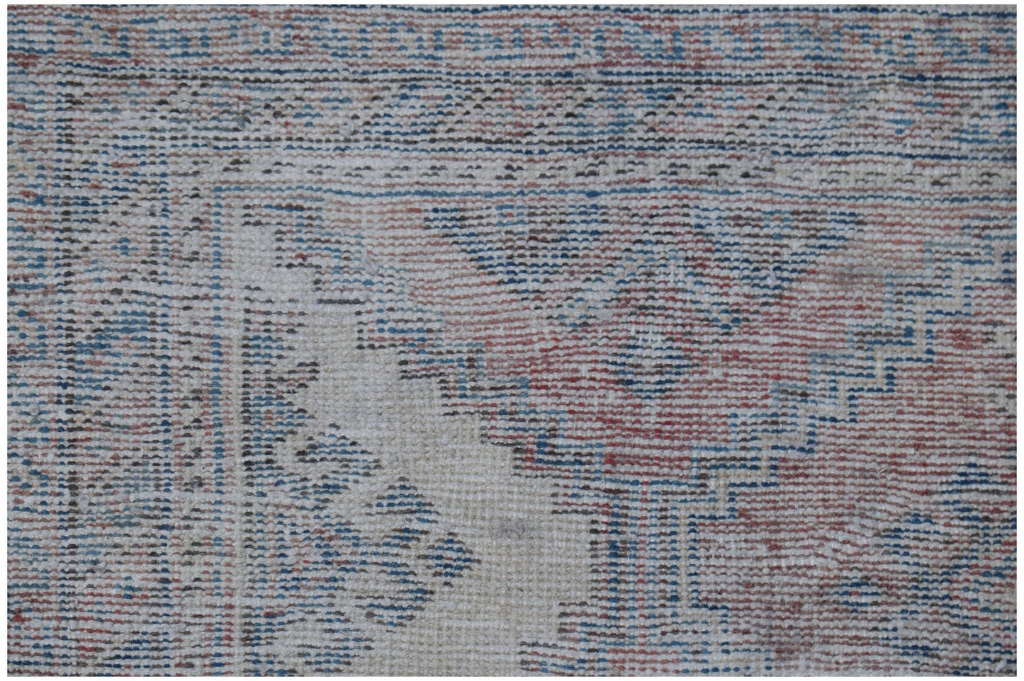 A vintage handmade Persian rug featuring a traditional pattern in faded red and blue tones.