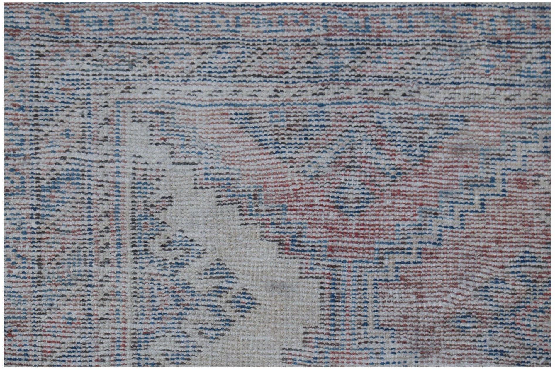 A vintage handmade Persian rug featuring a traditional pattern in faded red and blue tones.