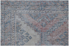 A vintage handmade Persian rug featuring a traditional pattern in faded red and blue tones.