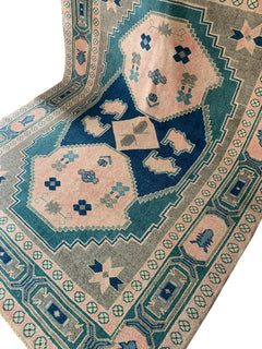 Handmade vintage Turkish Kars rug featuring geometric patterns in green, pink, and blue.