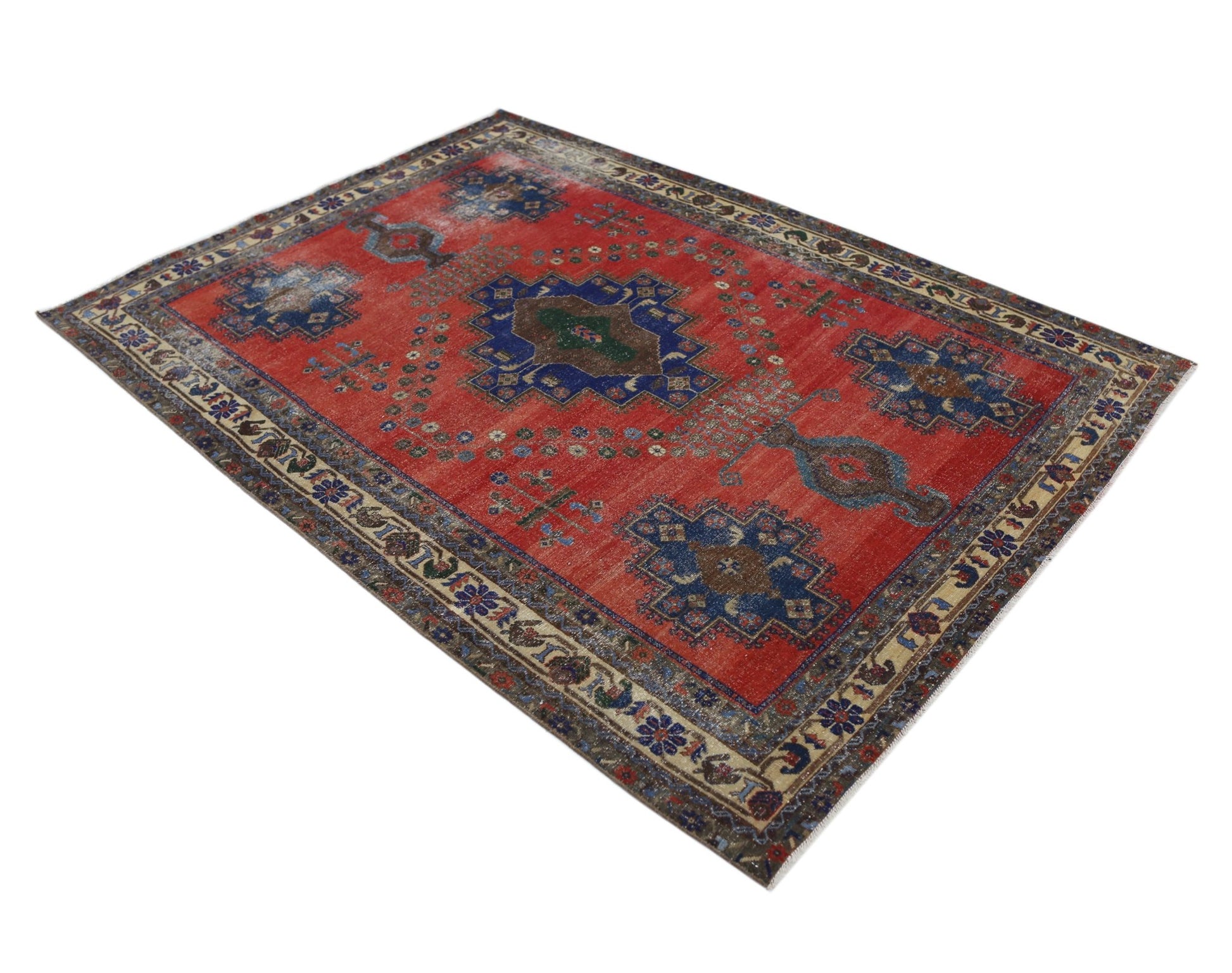 A vintage handmade Persian rug featuring a red field with blue and brown geometric medallions.