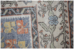 A close-up of a vintage Persian rug featuring intricate floral patterns in blue, orange, and yellow.