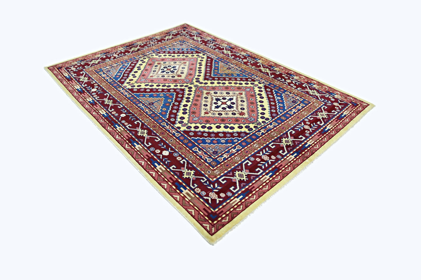 A vintage handmade Turkish rug featuring a geometric pattern in red, blue, and cream tones.