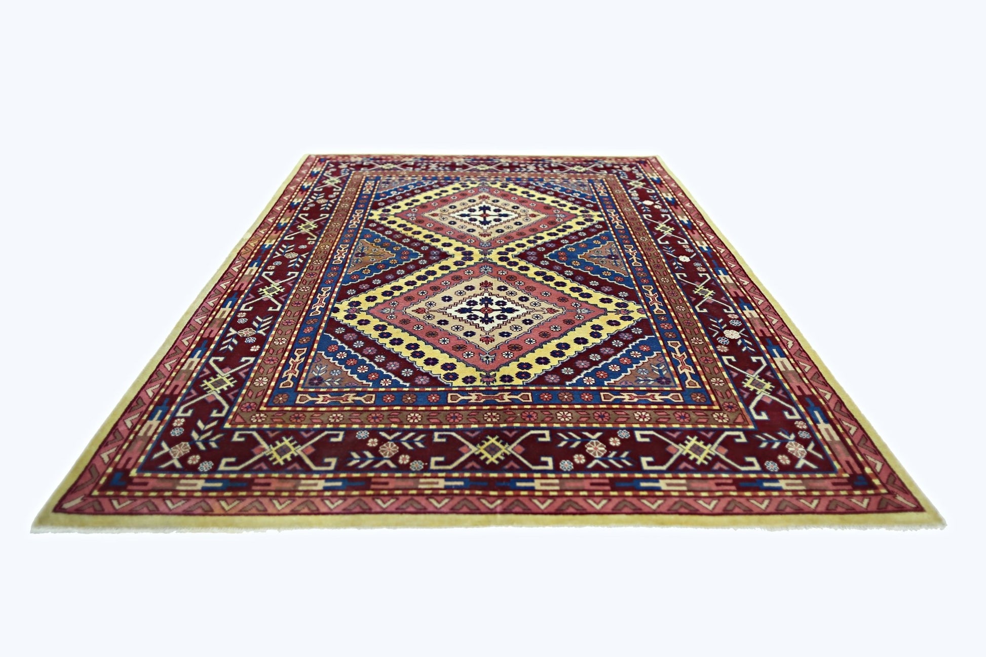 A vintage handmade Turkish rug featuring a geometric diamond pattern in red, blue, and yellow.