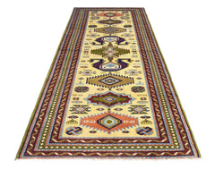 A vintage handmade Turkish runner rug featuring geometric patterns in earthy tones on a cream base.