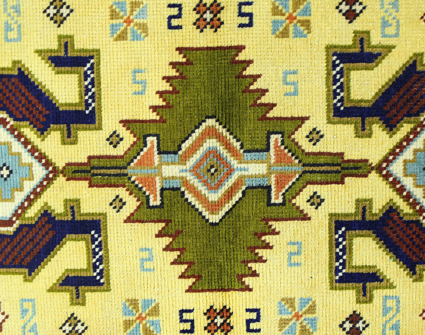 A vintage Turkish runner featuring a geometric green medallion pattern on a yellow background.