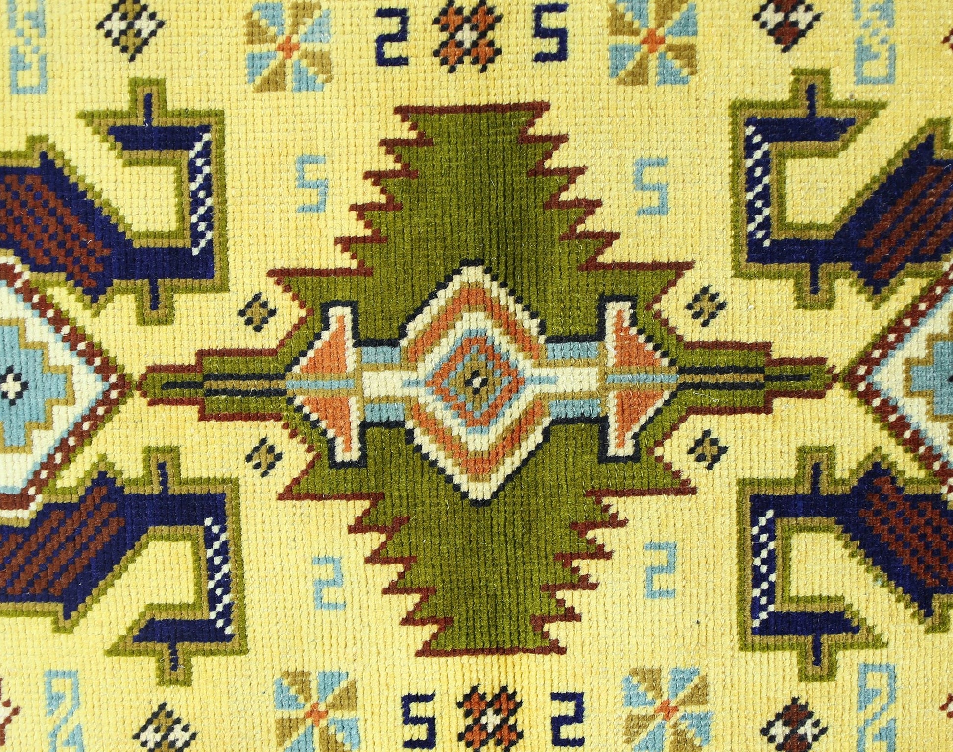 A vintage Turkish runner featuring a geometric green medallion pattern on a yellow background.