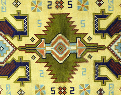 A vintage Turkish runner featuring a geometric green medallion pattern on a yellow background.
