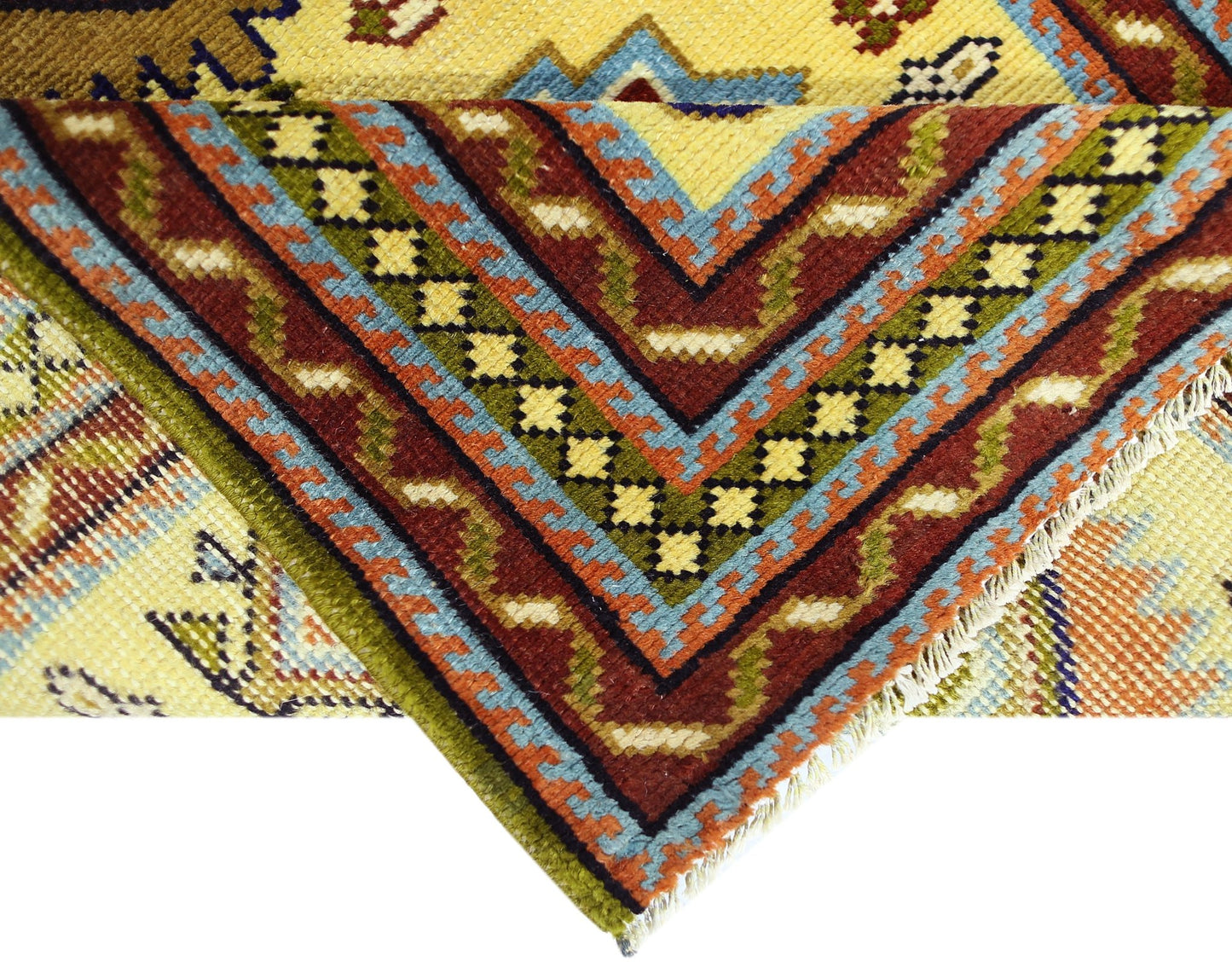 A close-up of a vintage Turkish runner featuring geometric patterns in red, blue, and yellow.