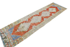 Vintage Turkish runner with red, blue, and cream tribal motifs.