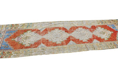 Vintage Turkish runner with tribal motifs in red, blue, and cream.