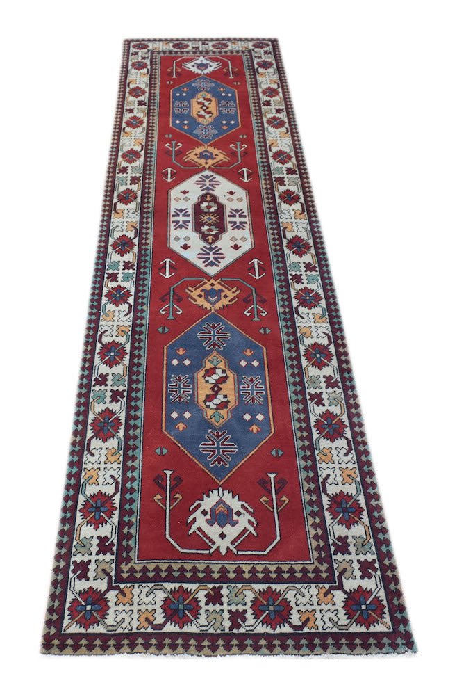 Vintage Turkish runner with red, blue, and white geometric patterns.