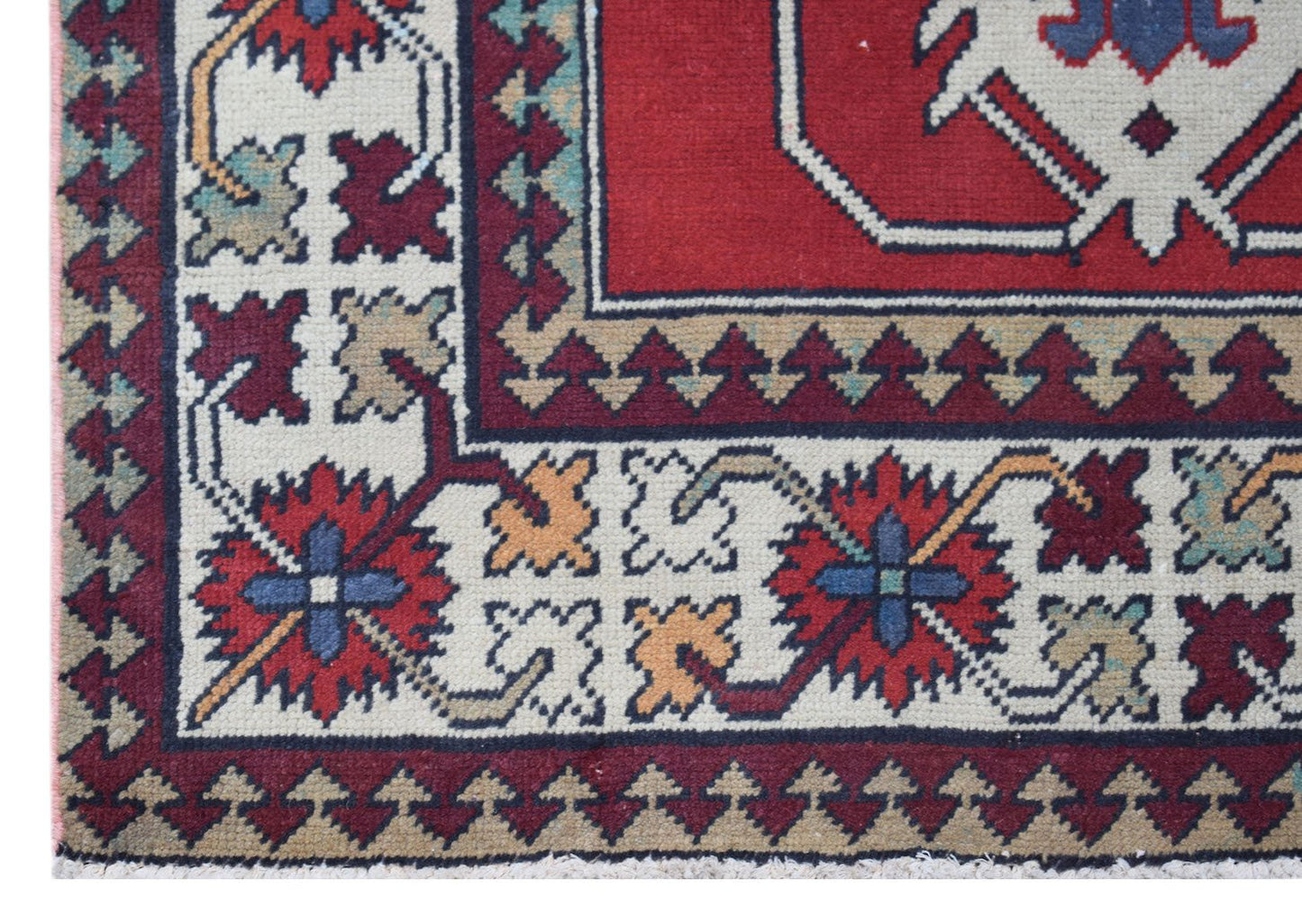 A vintage Turkish runner featuring a geometric floral pattern in red, blue, and cream tones.