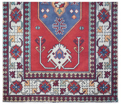 A vintage Turkish runner rug featuring a red field with a blue medallion and geometric patterns.