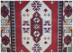 A vintage Turkish runner featuring a central geometric medallion on a red and cream field.