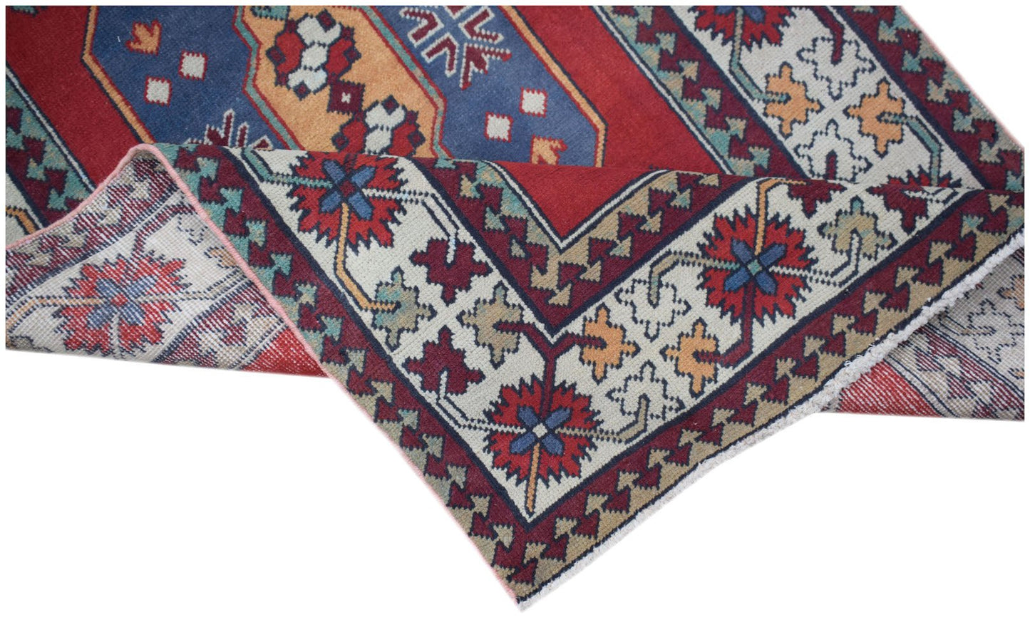A handwoven vintage Turkish runner featuring a geometric floral pattern in red, blue, and cream.