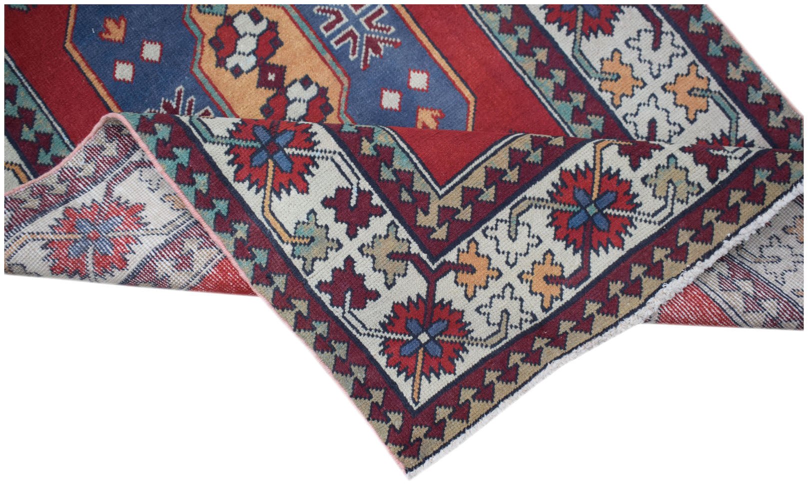 A handwoven vintage Turkish runner featuring a geometric floral pattern in red, blue, and cream.