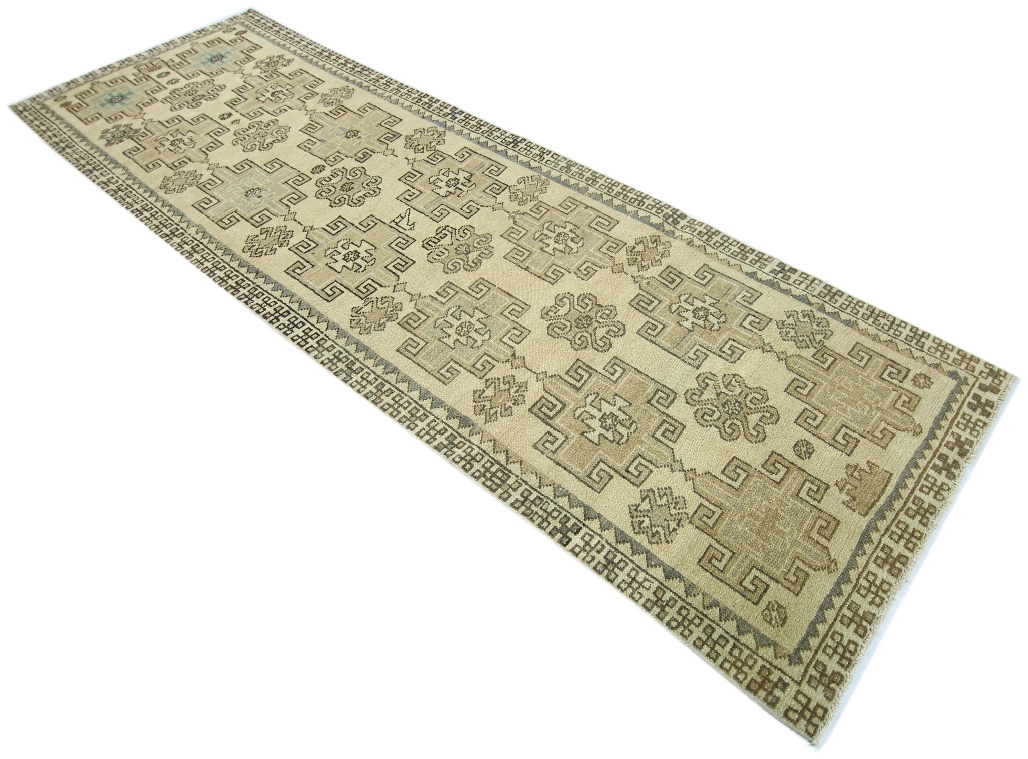 A vintage Anatolian runner rug featuring geometric patterns in neutral beige and grey tones.